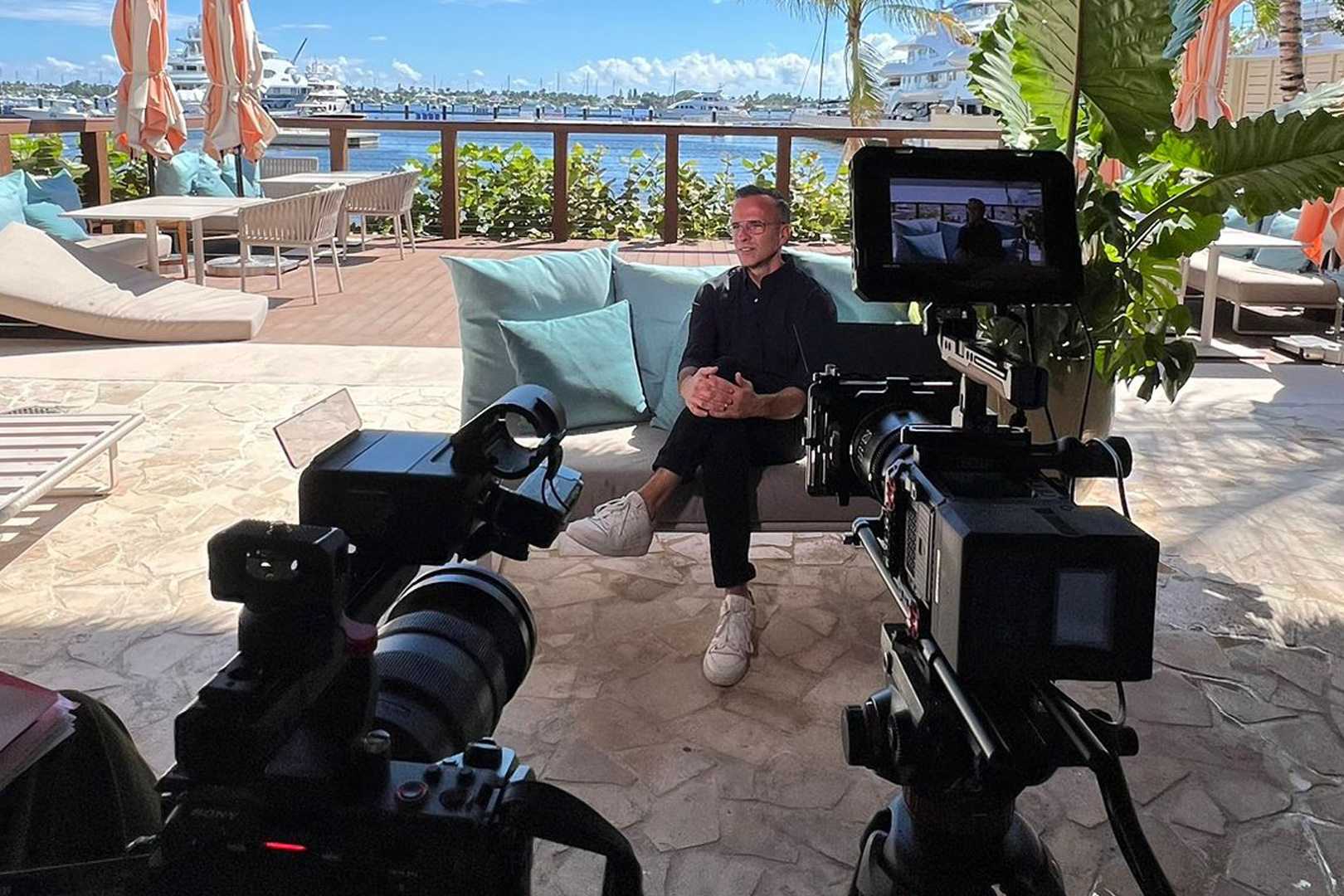 Two-camera interview setup on a waterfront terrace in South Florida